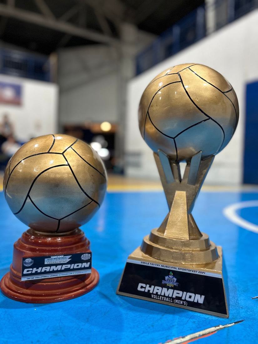 Two gold champion trophies on a court