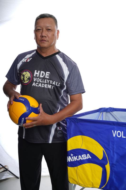 An HDE coach holding a Mikasa volleyball