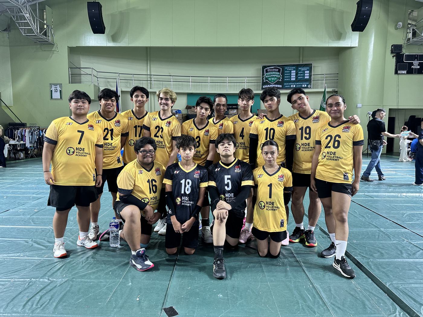 HDE boys in gold and black jerseys lined up in a sports hall