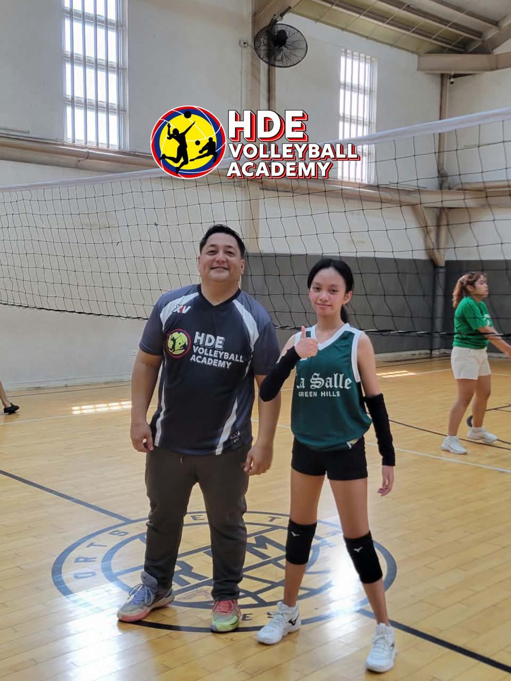 An HDE coach and a player side by side on court after a one on one session